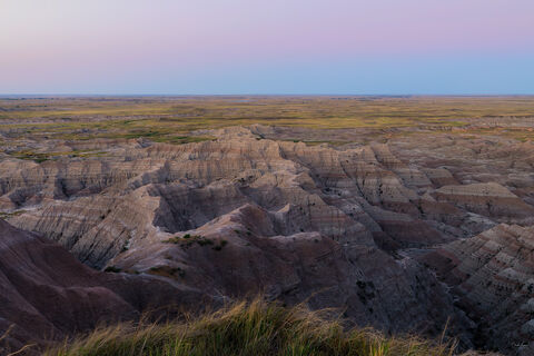 View of colorful buttes at Badlands National Park in South Dakota at sunset.