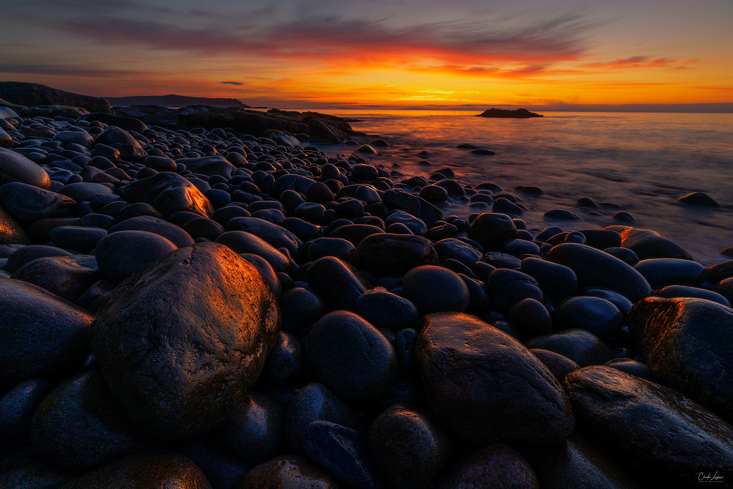 Colorful sunrise at Boulder Beach in Acadia National Park in Maine.