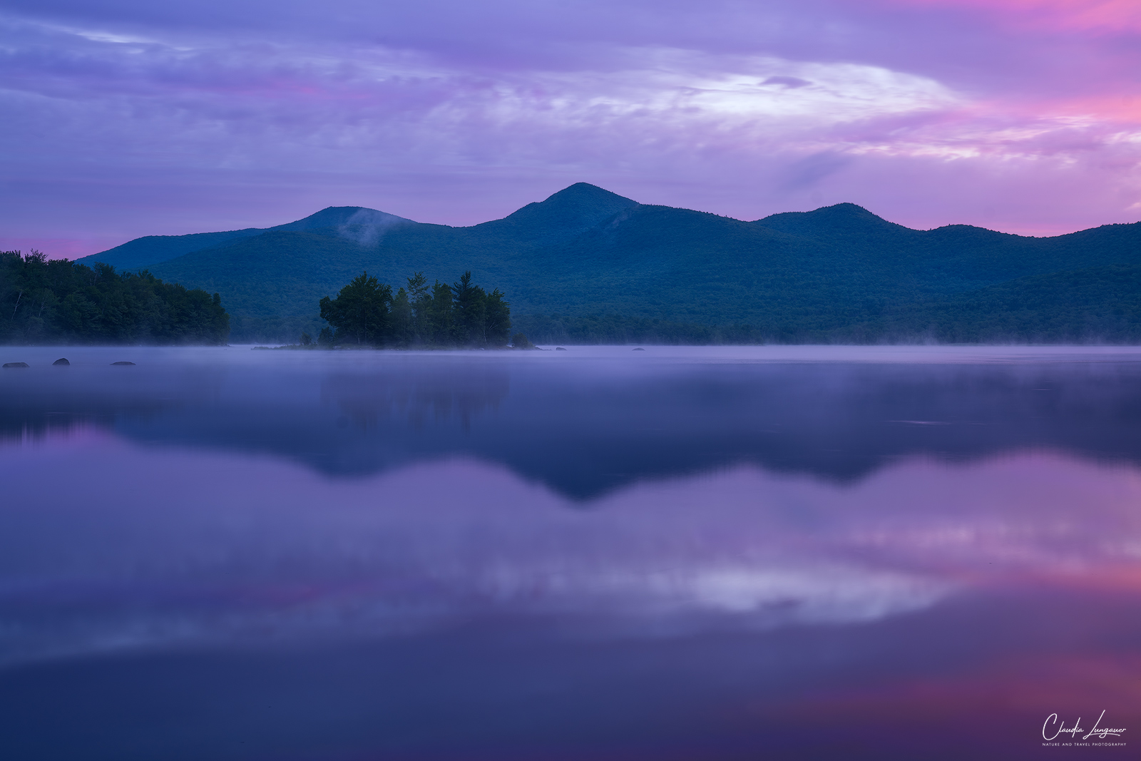 Colorful sunrise with mist and fog at Leffert's Pond in Vermont.