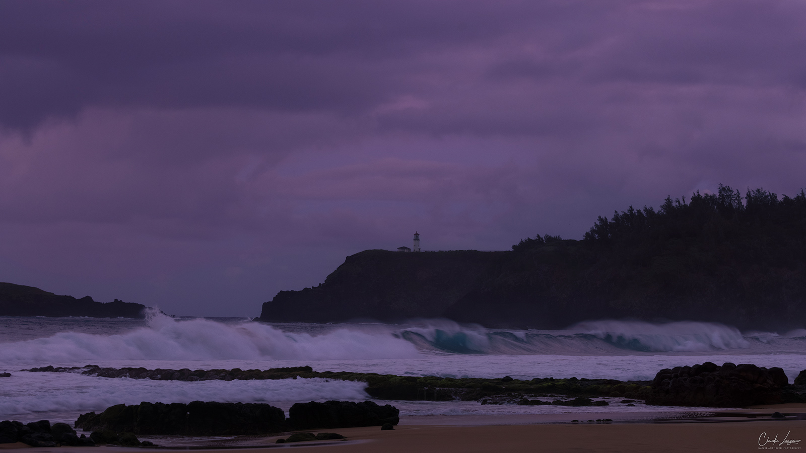 Big waves at Secret Beach, Kauai in Hawaii with Kilaulea lighthouse in the background.
