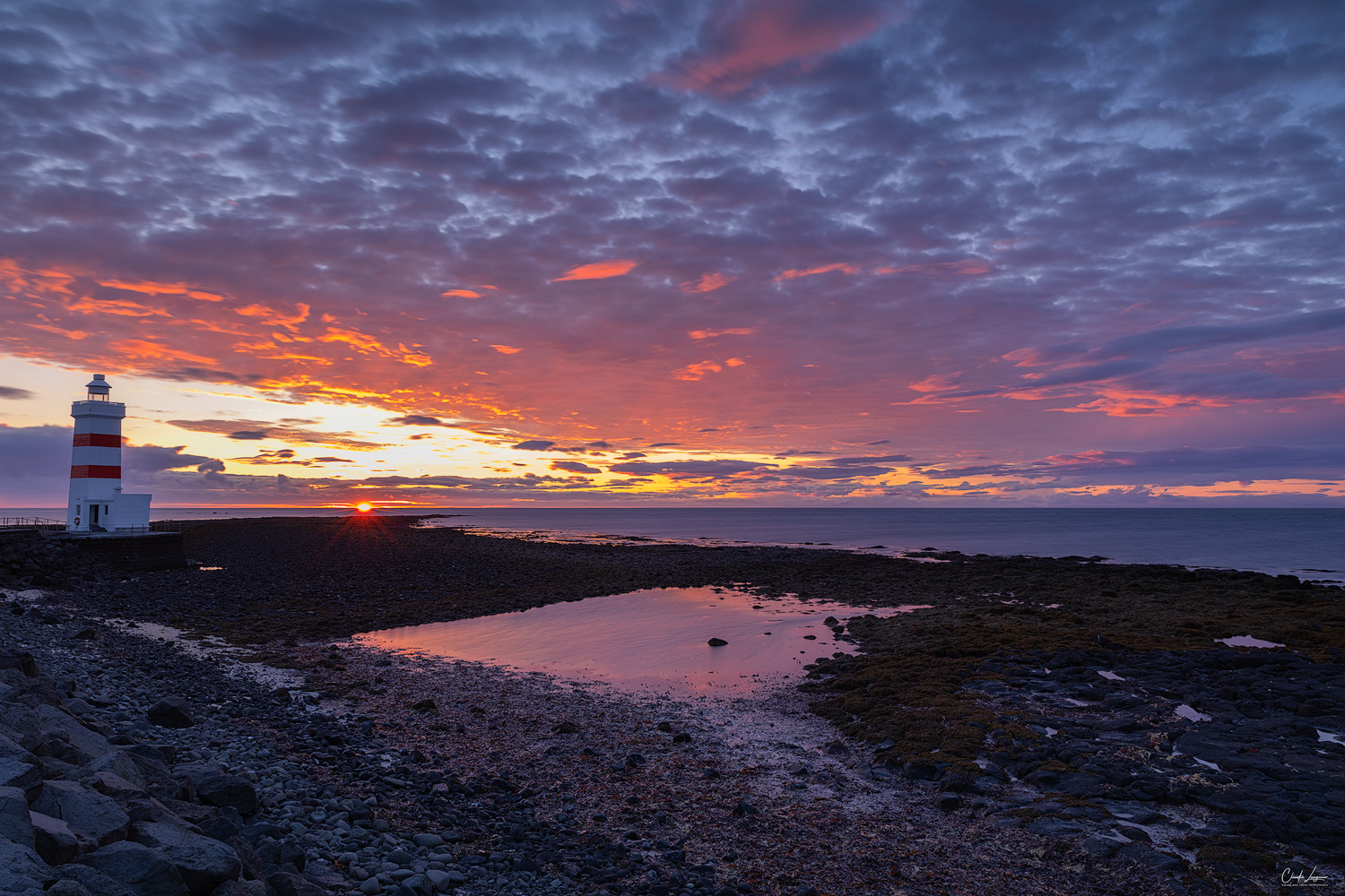 View of Gardur Lighthouse in Iceland at sunset.