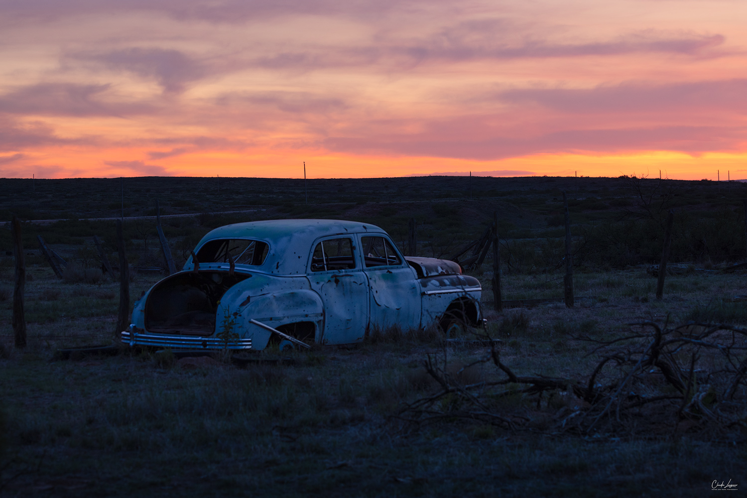 View of abandoned car in the ghost town of Endee in New Mexico at sunset.