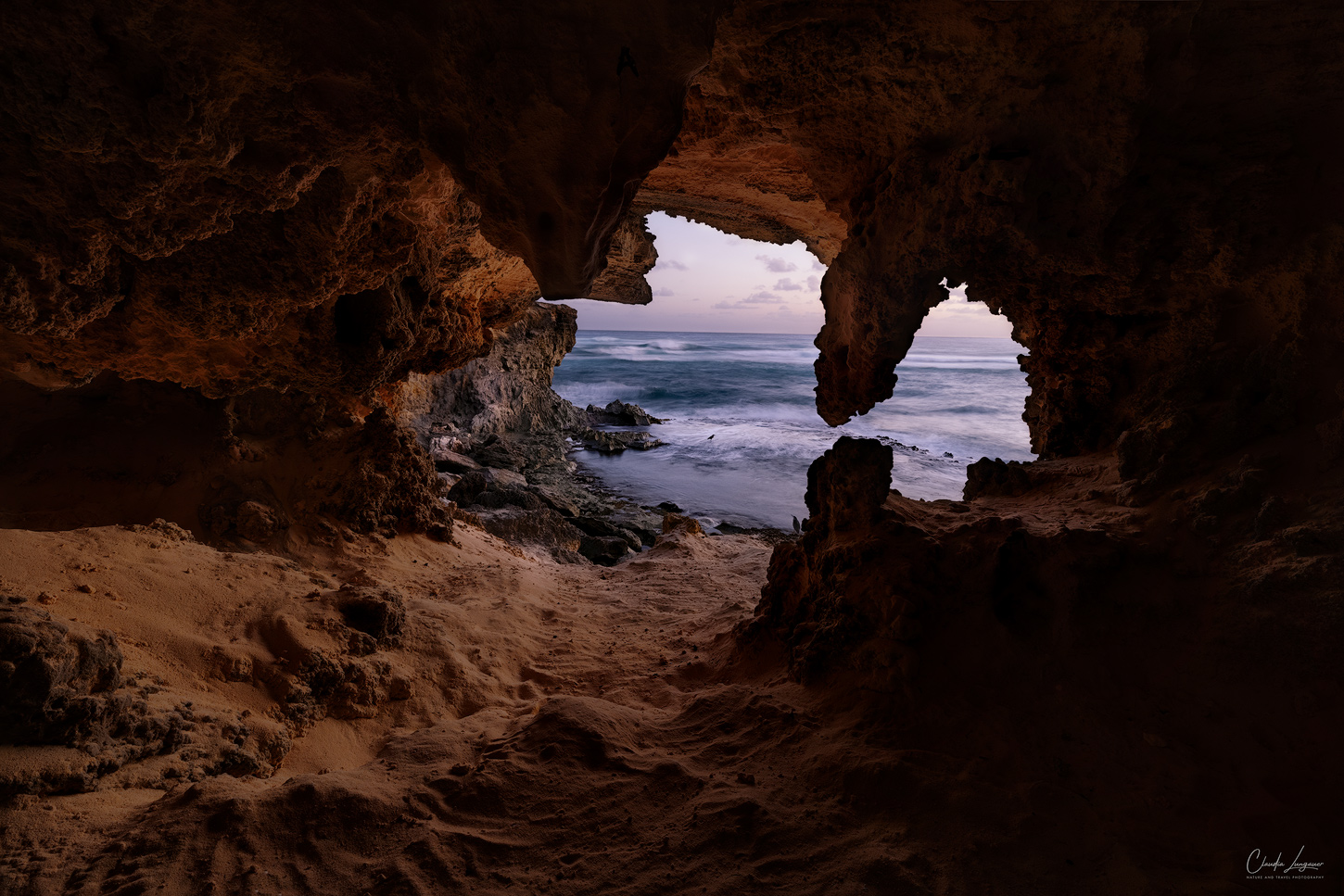 A cave near Shipwreck beach on the south shore of Kauai island in Hawaii with view on the Pacific Ocean.